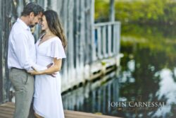 engagement photo of couple near a wooden boardwalk by water, scenic couples portrait