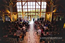 Indoor wedding ceremony with long petal-strewn aisle