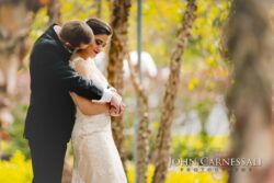 Groom hugging bride under birch trees