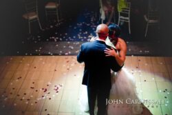 Bride and groom dancing under soft lighting.