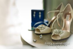 Bridal shoes and jewelry on a table.