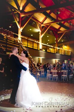 Newlyweds dancing beneath timber trusses