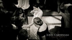 Bride sipping cocktail surrounded by dancing friends