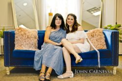 Two women sitting on a blue couch.