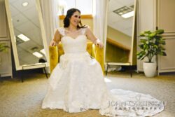 Bride sitting in a wedding dress, smiling.