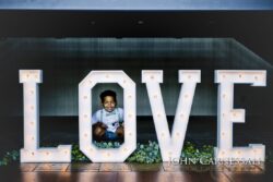 Boy smiling inside large "LOVE" letters.