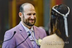 Groom smiling during wedding ceremony.