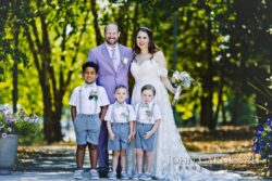 Wedding couple with three young boys outdoors.