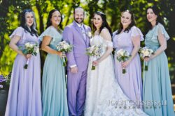Bride, groom, and bridesmaids in pastel dresses.