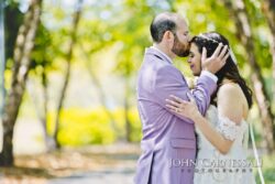 Bride and groom embracing in sunny park.