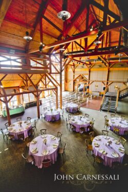 Spacious banquet hall with round tables decorated.