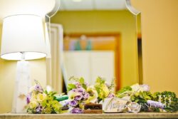 Bouquet and lamp on a mirrored table.