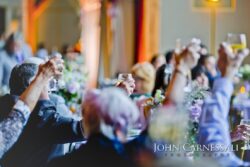 People raising glasses in celebration toast.