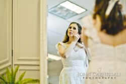 Bride adjusting earring in front of mirror.