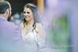 Bride smiling during vows, lace gown