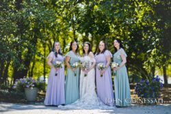 Bride and bridesmaids in pastel dresses outdoors.