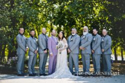 Wedding party posing in outdoor setting.