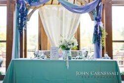 Wedding table with floral decorations and drapes.