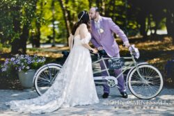 Bride and groom kissing near bicycle.