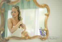 Woman in mirror adjusting her hair.