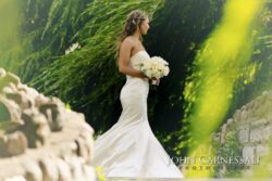 Bride walking outdoors with floral bouquet.