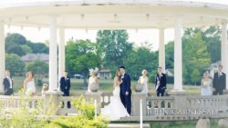 Wedding party posing in park gazebo.
