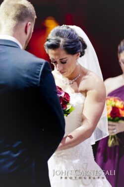 Bride holding red bouquet, eyes closed