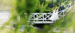 Bride descending white garden bridge with groom