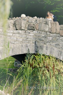 Bride and groom on stone bridge.