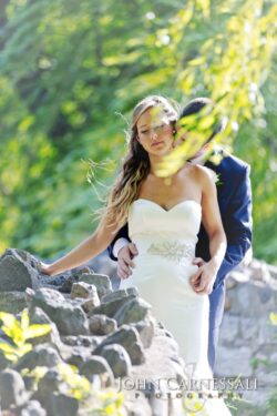 Bride embraced by groom under willow branches