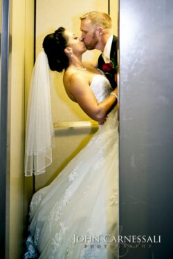 Veiled bride and groom kiss in elevator