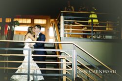Bride and groom kissing on staircase.
