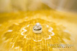 Wedding rings on patterned golden surface.