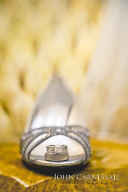Wedding rings inside elegant high-heeled shoe.