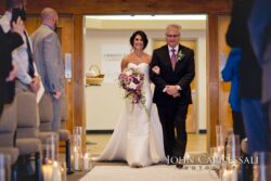 Bride walking down candlelit aisle
