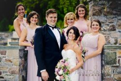 Bride and groom with bridesmaids outdoors.