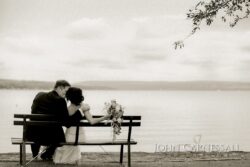Couple sitting on bench by the lake.
