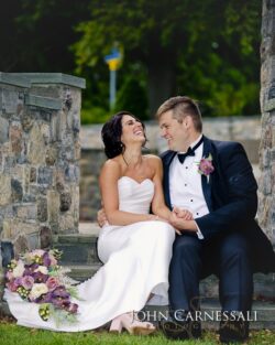 Bride and groom laughing on stone steps.
