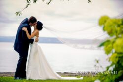 Wedding kiss with flowing veil by lake