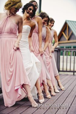 Bridesmaids and bride in pink dresses posing.