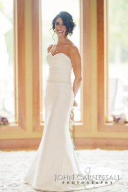 Bride in elegant white wedding dress indoors.