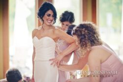 Bride getting ready with bridesmaids assisting.