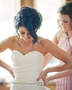 Bride smiling while adjusting wedding dress.