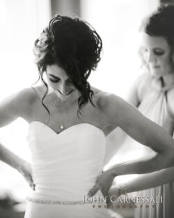 Bride adjusting dress with bridesmaid's help