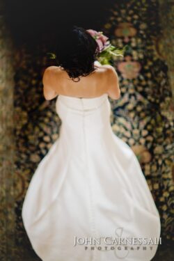 Bride in white dress holding bouquet, overhead.