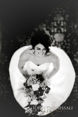 Bride smiling with bouquet, black and white.