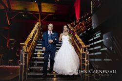 Bride descending staircase escorted by father