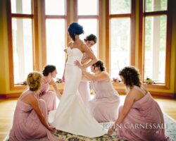 Bride preparation with bridesmaids in pink dresses.