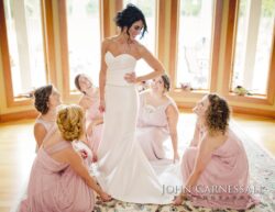 Bride smiling, bridesmaids seated around her