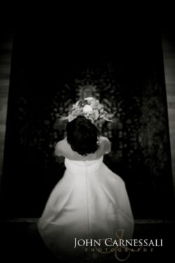 Bride holding bouquet in elegant wedding dress.